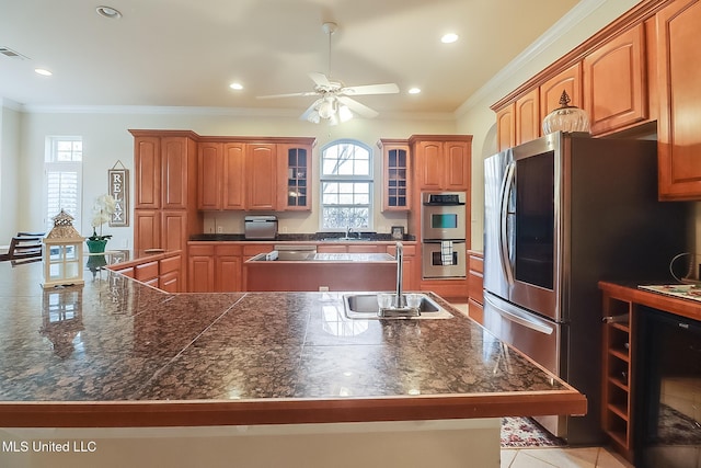 kitchen with glass insert cabinets, stainless steel appliances, a sink, and ornamental molding