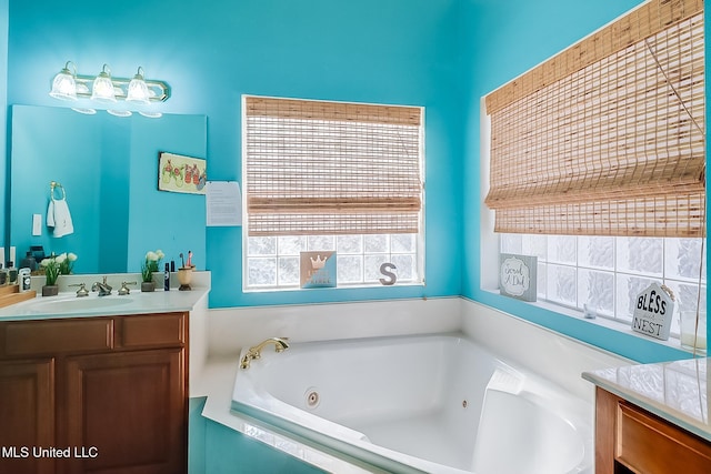 bathroom with a tub with jets and vanity