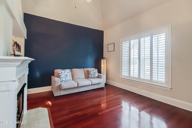 living room with a fireplace with flush hearth, wood finished floors, and baseboards