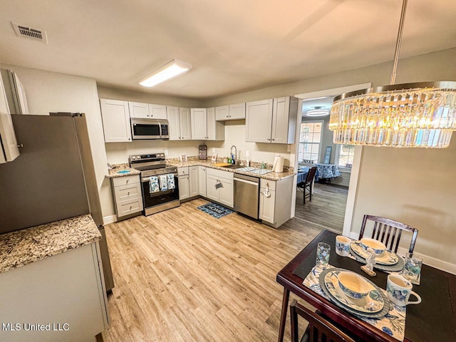 kitchen with stainless steel appliances, light hardwood / wood-style floors, sink, and white cabinets