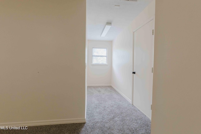 corridor featuring carpet, visible vents, and baseboards
