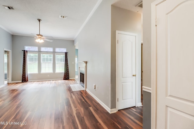 16383 Clearwater Cir, Gulfport, MS 39503 - unfurnished living room featuring wood finished floors, a ceiling fan, crown molding, and a fireplace with flush hearth