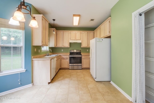 16383 Clearwater Cir, Gulfport, MS 39503 - kitchen with white appliances, light brown cabinetry, under cabinet range hood, light countertops, and decorative light fixtures