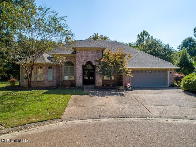 view of front of property with a front lawn and a garage