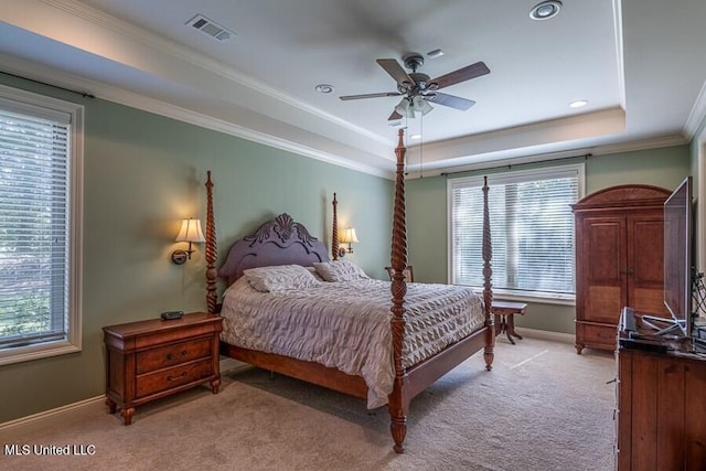 carpeted bedroom with ceiling fan, a raised ceiling, and crown molding