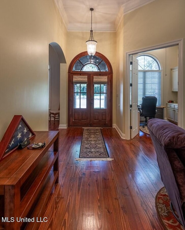 foyer entrance with french doors, dark hardwood / wood-style floors, and ornamental molding