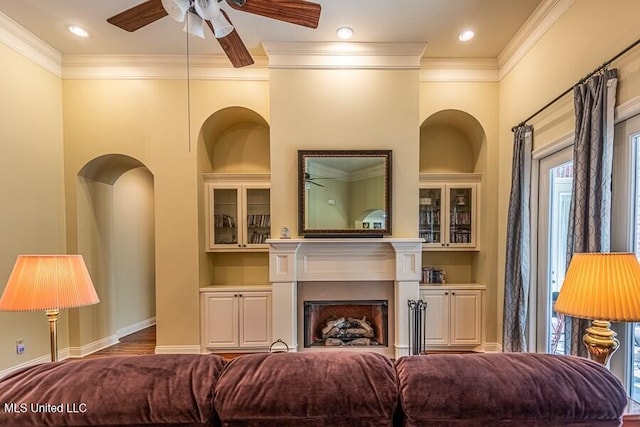 living room featuring a wealth of natural light, ornamental molding, and ceiling fan