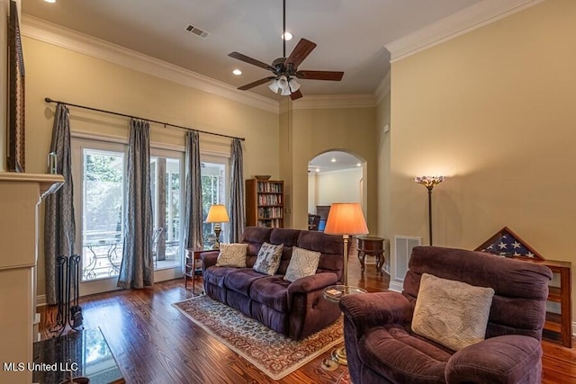 living room featuring dark wood-type flooring, ceiling fan, and ornamental molding