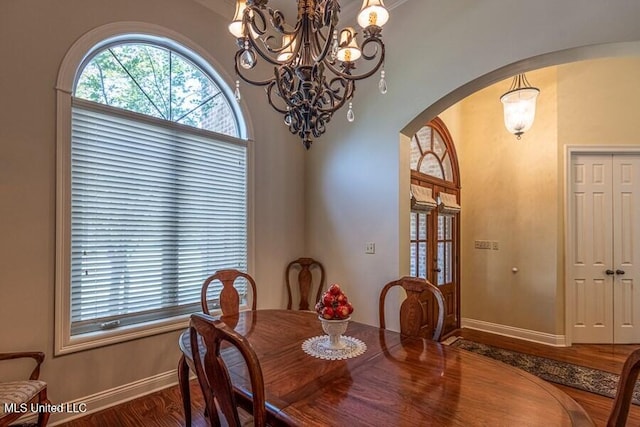 dining area with wood-type flooring and an inviting chandelier