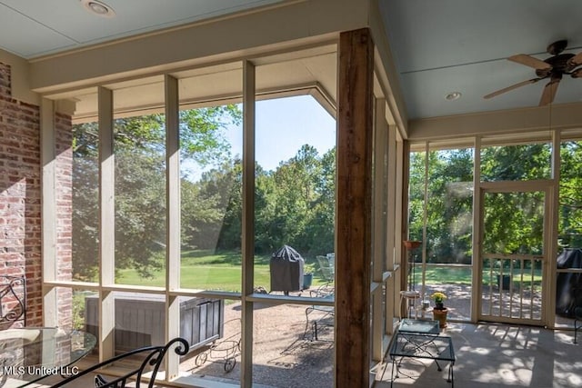 unfurnished sunroom with ceiling fan