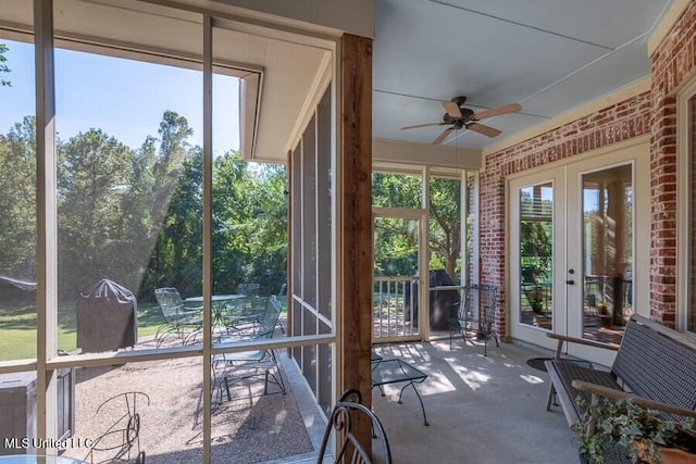 unfurnished sunroom with ceiling fan, plenty of natural light, and french doors