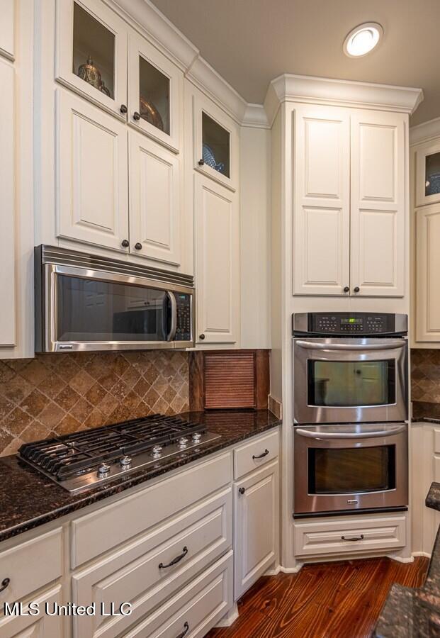 kitchen featuring white cabinets, dark stone counters, and appliances with stainless steel finishes