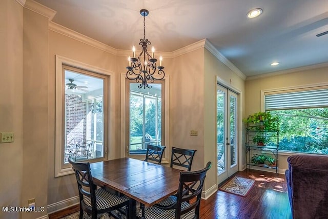 dining area with ceiling fan with notable chandelier, dark hardwood / wood-style flooring, and crown molding