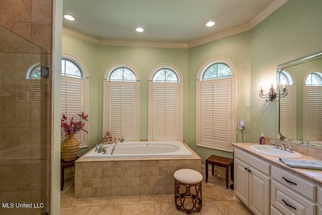 bathroom featuring tile patterned flooring, vanity, crown molding, and tiled tub