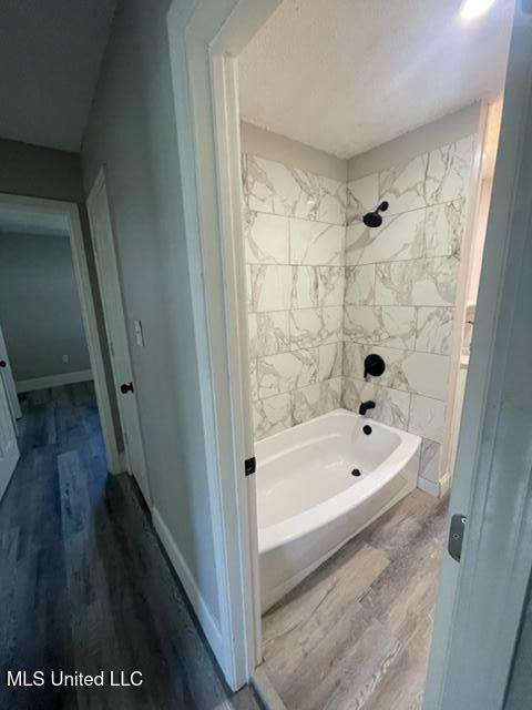 bathroom with wood-type flooring and tiled shower / bath combo