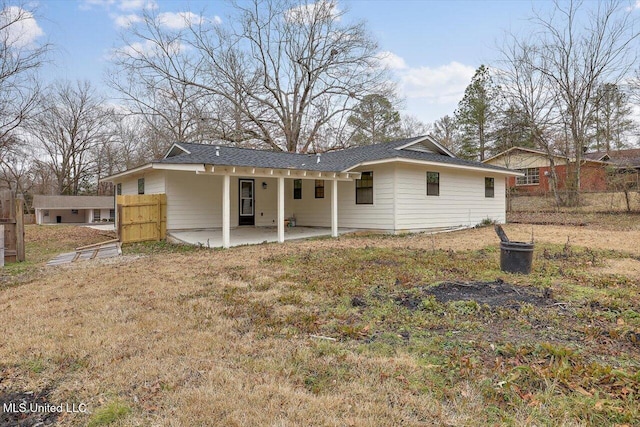 rear view of house with a patio and a lawn