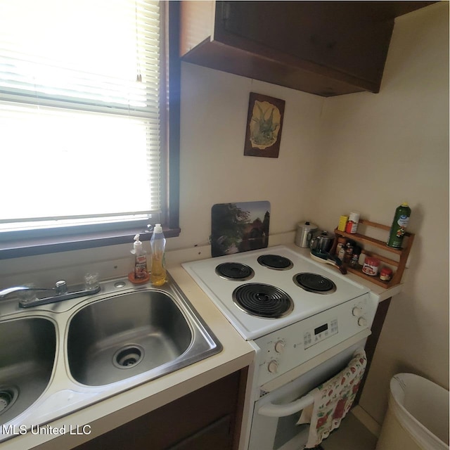 kitchen with white range with electric cooktop, a sink, exhaust hood, and light countertops