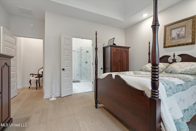 bedroom with light wood-type flooring and ensuite bath