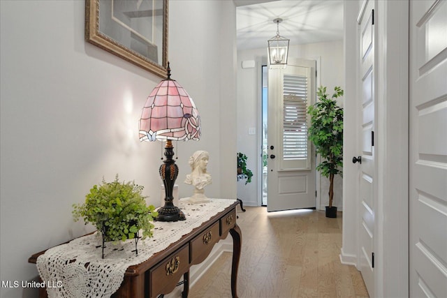 entrance foyer with light wood-type flooring and an inviting chandelier