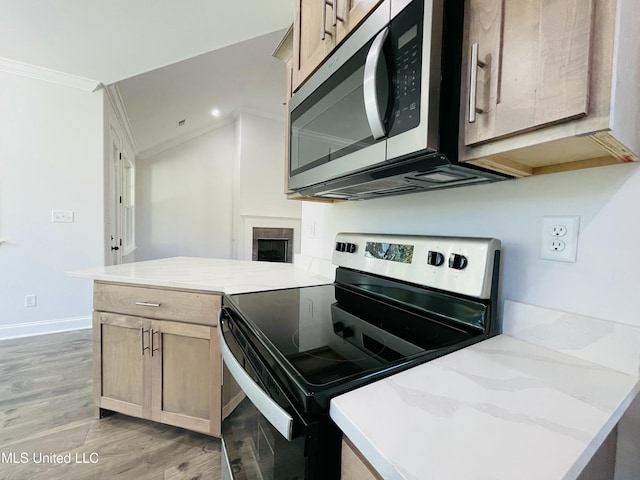 188 E Byhalia Creek Farms Rd, Byhalia, MS 38611 - kitchen featuring appliances with stainless steel finishes, a peninsula, crown molding, light wood-style flooring, and a tile fireplace