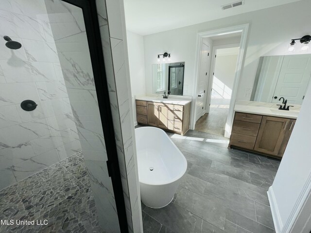 188 E Byhalia Creek Farms Rd, Byhalia, MS 38611 - bathroom with a freestanding tub, tiled shower, and two vanities