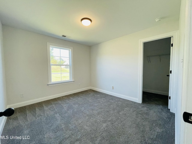 188 E Byhalia Creek Farms Rd, Byhalia, MS 38611 - unfurnished bedroom with dark carpet, baseboards, and a spacious closet