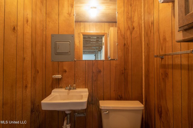 5100 Monroe Ave, Gulfport, MS 39507 - half bath with electric panel, wooden walls, a sink, and toilet
