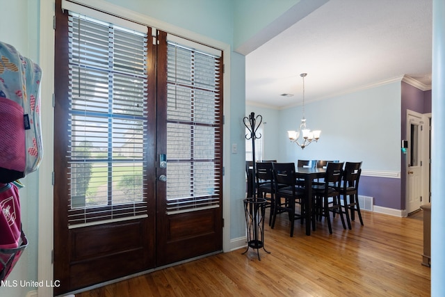 12857 Arbor Dr, Olive Branch, MS 38654 - dining space featuring healthy amount of natural light, wood finished floors, a chandelier, crown molding, and french doors