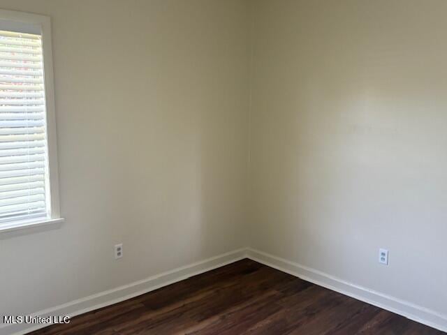 1108 W President Ave, Greenwood, MS 38930 - unfurnished room with dark wood-style flooring, healthy amount of natural light, and baseboards