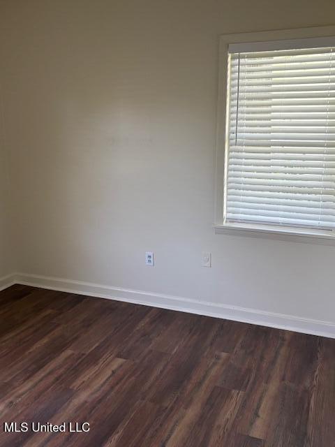 1108 W President Ave, Greenwood, MS 38930 - unfurnished room with baseboards and dark wood-style flooring