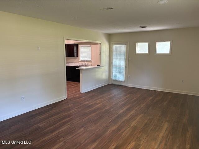 1108 W President Ave, Greenwood, MS 38930 - empty room with baseboards and dark wood-type flooring
