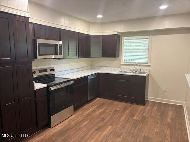1108 W President Ave, Greenwood, MS 38930 - kitchen with stainless steel appliances, a sink, light countertops, and dark wood-type flooring