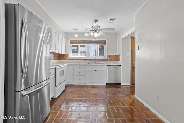 kitchen featuring visible vents, brick floor, stainless steel appliances, white cabinetry, and a sink