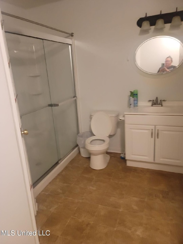 bathroom with walk in shower, vanity, and toilet