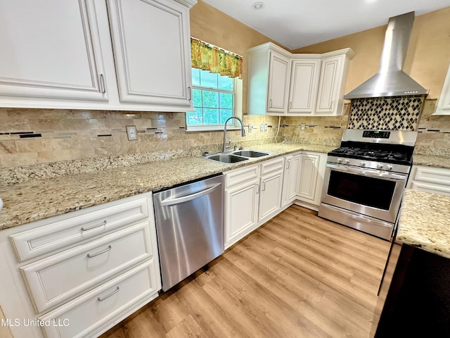 13456 John Clark Rd, Gulfport, MS 39503 - kitchen with stainless steel appliances, wall chimney exhaust hood, a sink, and light wood-style flooring