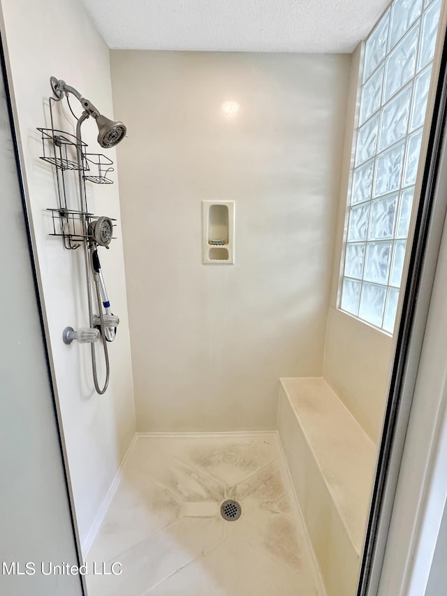 13456 John Clark Rd, Gulfport, MS 39503 - bathroom with a shower, a textured ceiling, and baseboards