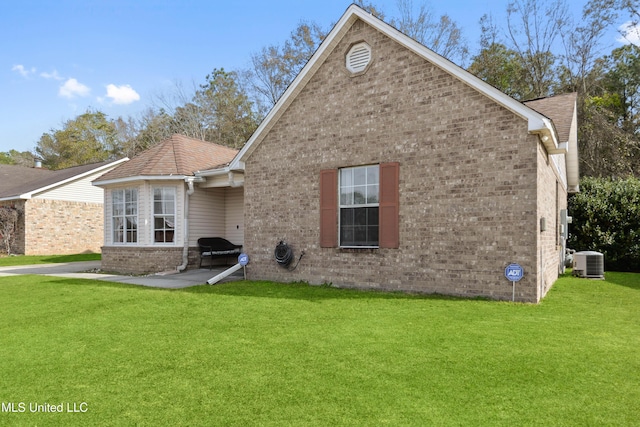 rear view of property featuring a patio, central AC unit, and a lawn