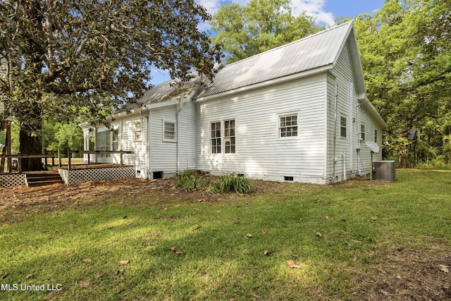 view of home's exterior featuring a wooden deck, crawl space, central air condition unit, a lawn, and metal roof