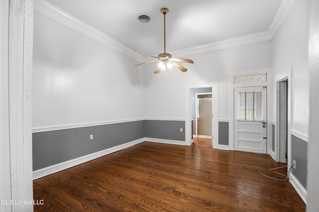 spare room with ornamental molding, a ceiling fan, wood finished floors, and visible vents