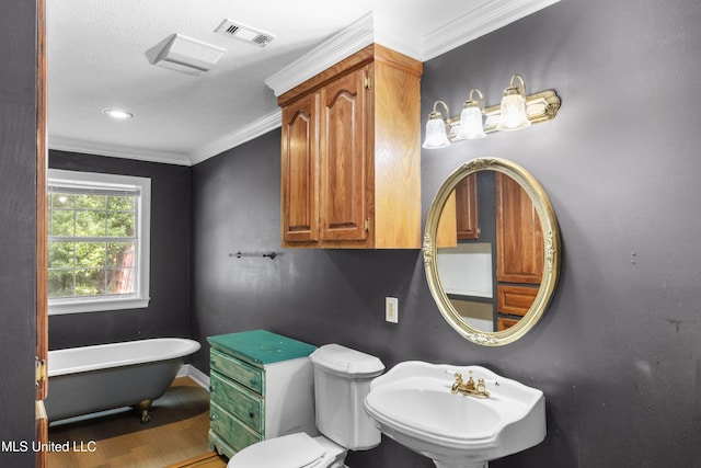 full bath with visible vents, ornamental molding, toilet, a freestanding bath, and a sink