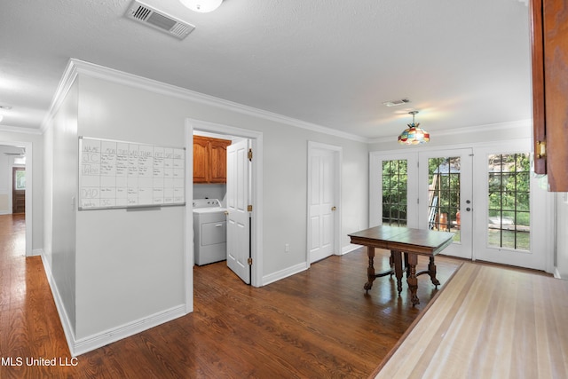 dining area featuring washer / dryer, crown molding, dark wood-style floors, and visible vents