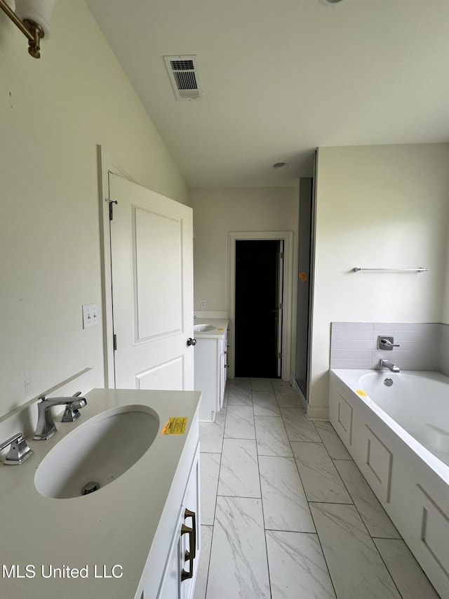 8 Shade Tree Dr, Carriere, MS 39426 - bathroom featuring vanity, marble look tile flooring, and a garden tub