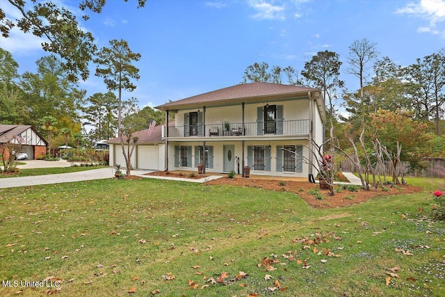 view of front facade with a porch, a balcony, a front lawn, and a garage