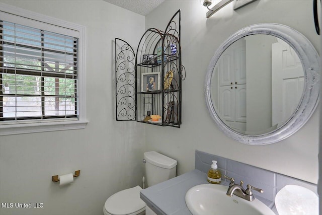 bathroom with vanity, a textured ceiling, and toilet