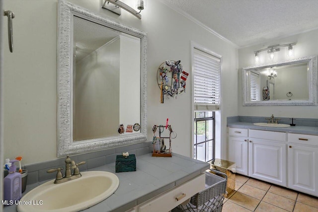 bathroom with vanity, a textured ceiling, tile patterned floors, and ornamental molding