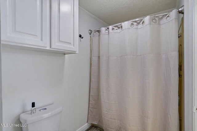 bathroom with ornamental molding, a shower with curtain, a textured ceiling, and toilet