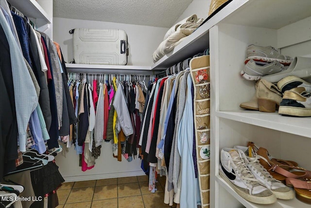 walk in closet with light tile patterned floors