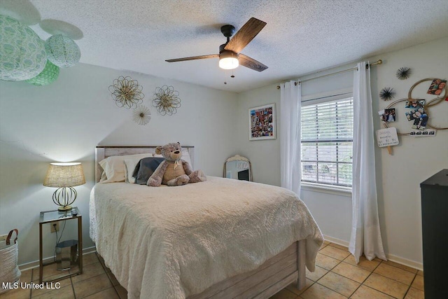 bedroom with ceiling fan, a textured ceiling, and light tile patterned floors