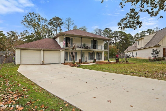 view of front of house with a front yard, a garage, and a balcony