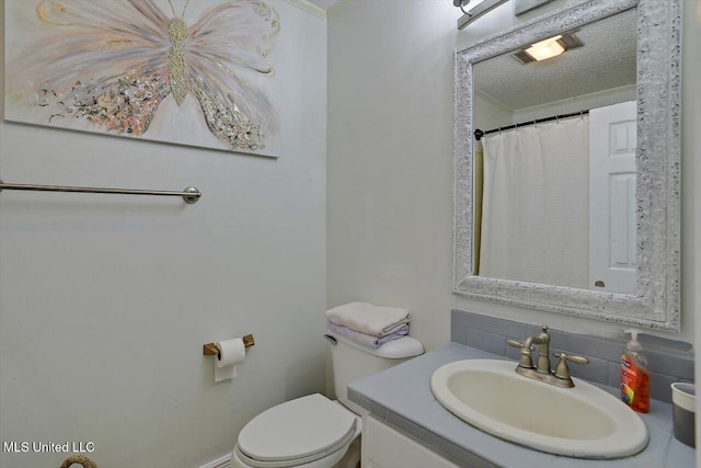 bathroom with vanity, a textured ceiling, and toilet